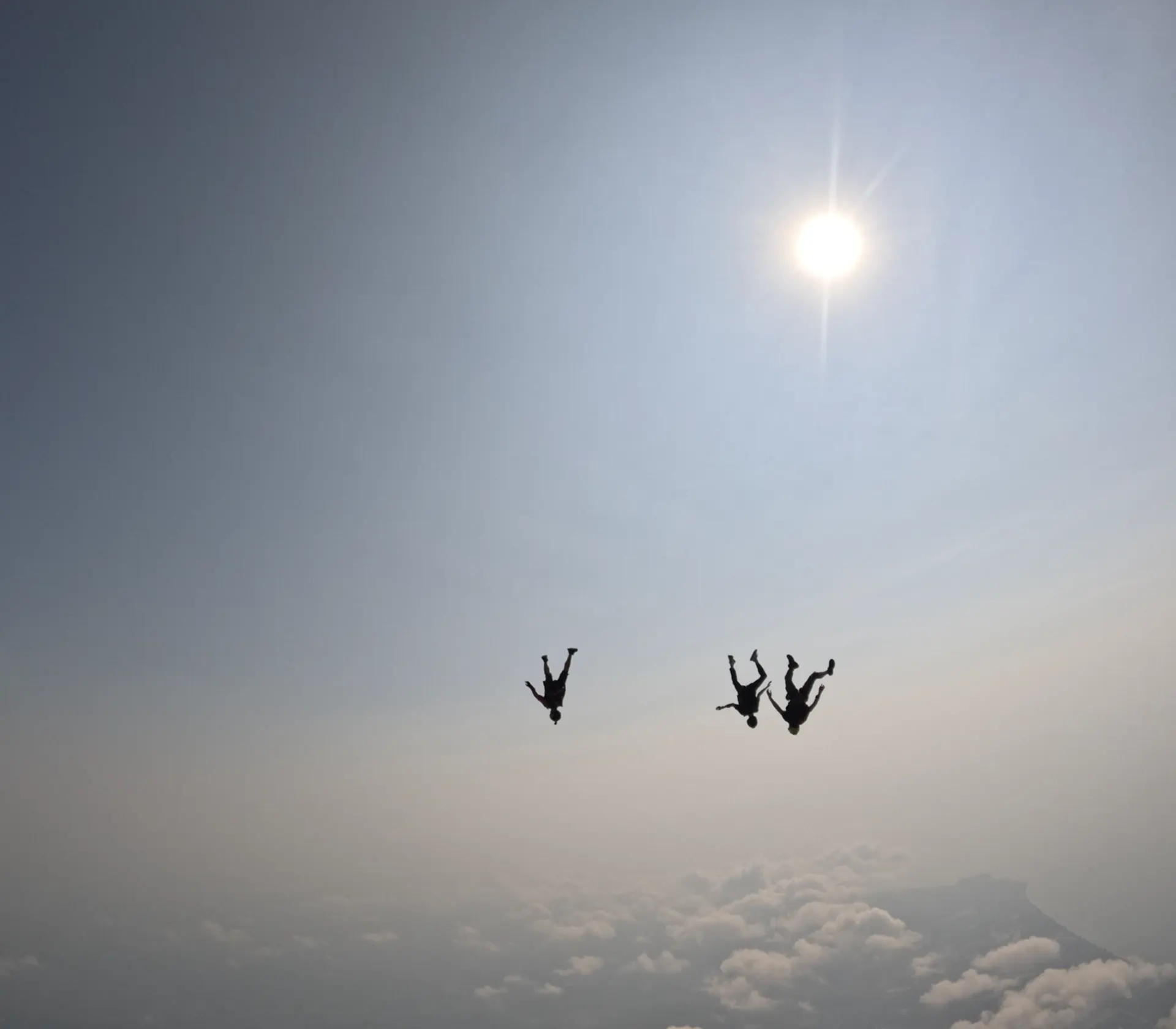 Skydivers in freefall at sunset